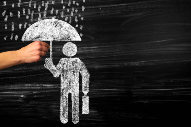 istock Businessman using umbrella for protection against driving rain 1283293626