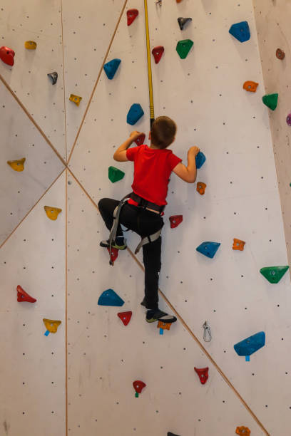 istock Young boy climbing with rope on climbing wall 1283297306