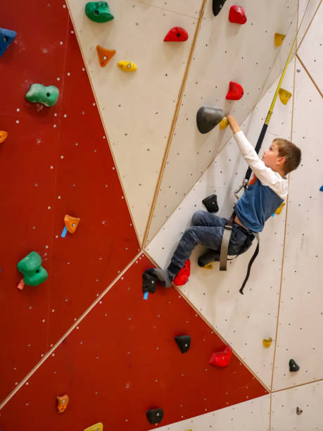 istock Young boy climbing with rope on climbing wall 1283297316