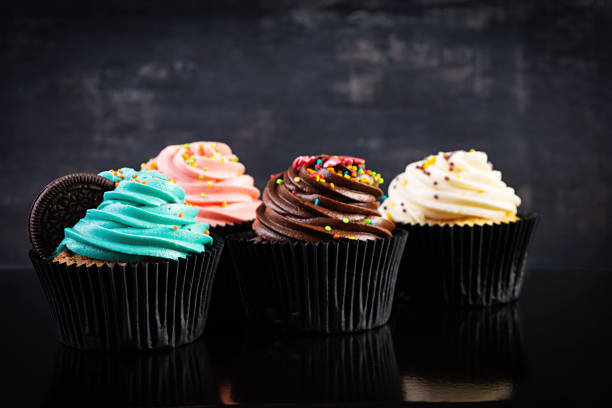 istock Tasty colorful cupcakes isolated on dark background. Delicious cupcake 1283300697