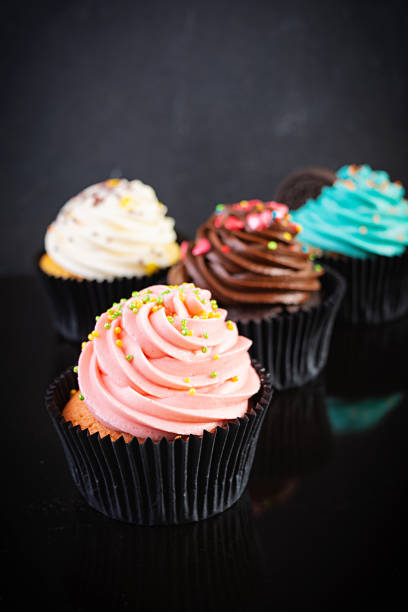 istock Tasty colorful cupcakes isolated on dark background. Delicious cupcake 1283300699