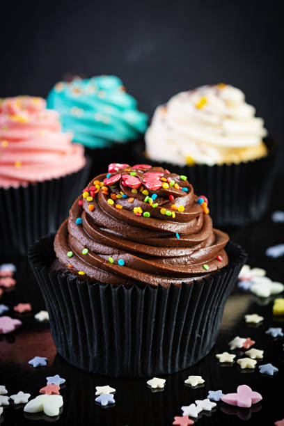 istock Tasty colorful cupcakes isolated on dark background. Delicious cupcake 1283300706