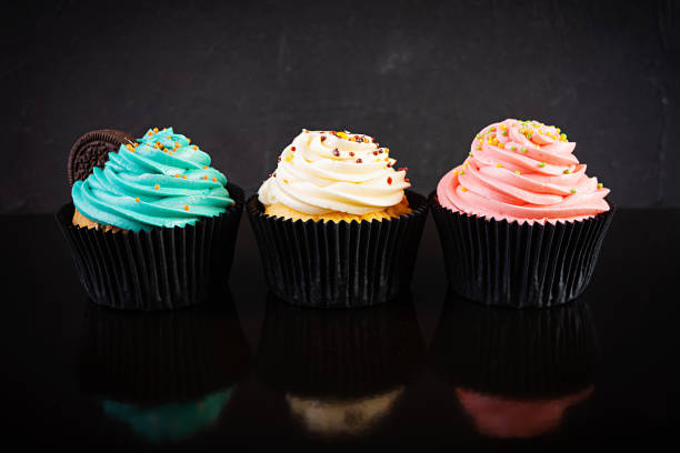 istock Tasty colorful cupcakes isolated on dark background. Delicious cupcake 1283300712