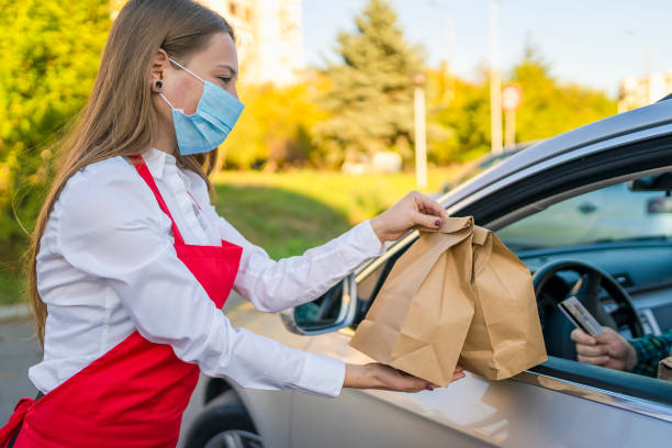 istock Order Being Passed Between  Hands Through Car Window Outside Restaurant During Covid-19 Lockdown 1283300747
