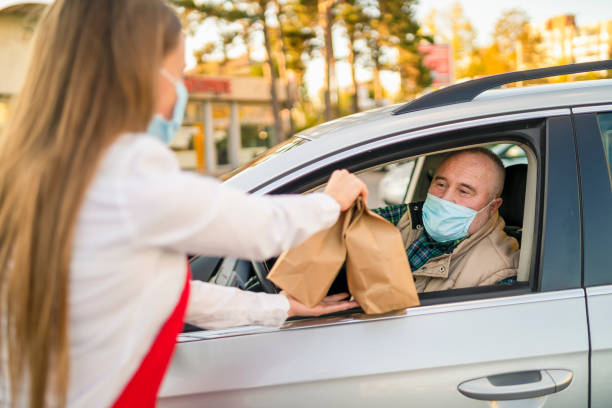 istock Order Being Passed Between  Hands Through Car Window Outside Restaurant During Covid-19 Lockdown 1283300757