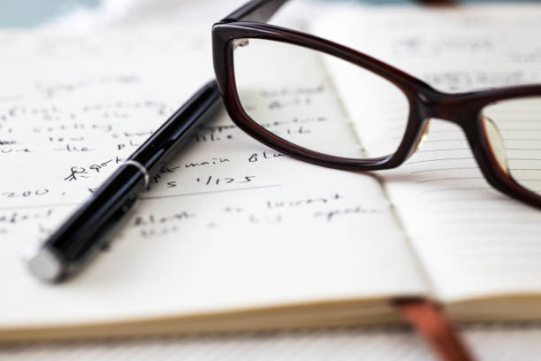 istock Closed up of spectacle, pen and a book 1283300999