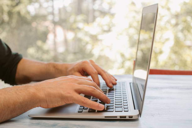 istock Man working on a laptop on rustic wooden table. Home working concept. Young man hands with computer. Home office. 1283301575