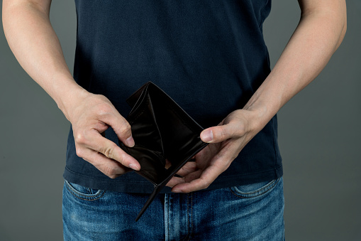 Man showing his empty leather wallet.