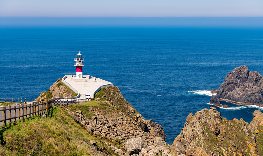 Beautiful coastal landscape with the lighthouse at Cape Ortegal on a cliff overlooking the blue Atlantic ocean, in the Galicia region of Spain.