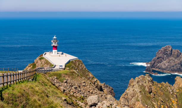 Beautiful coastal landscape at Cape Ortegal lighthouse in the Galicia region of Spain. Beautiful coastal landscape with the lighthouse at Cape Ortegal on a cliff overlooking the blue Atlantic ocean, in the Galicia region of Spain. headland stock pictures, royalty-free photos & images