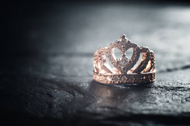 Ring in the form of a crown on a black stone background. Bijouterie products.