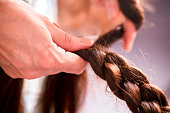 Mother braiding brunette girls long hair