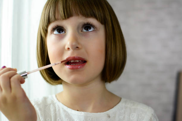 istock Little girl applying make up, using lipstick 1283305098
