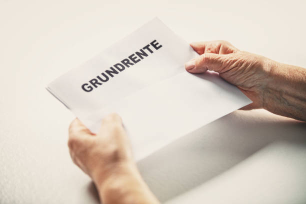 istock Senior or pensioner holding a letter with german word grundrente, basic pension, copyspace 1283308465