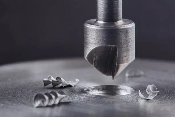 Photo of Countersink drill bit make sink in hole in steel billet. Locksmith work.