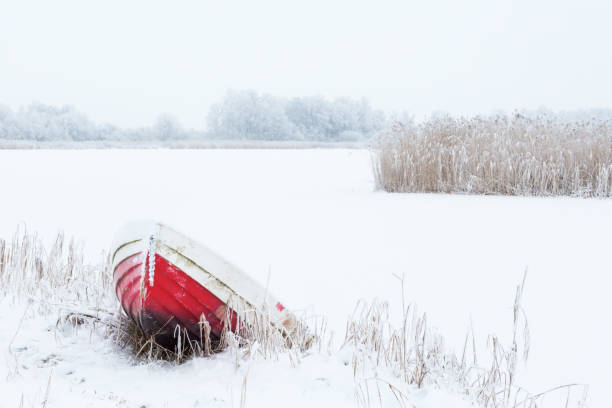 Wintry lake landscape with a boat on the beach