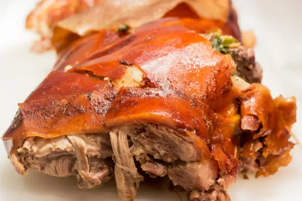 Photo of Roasted pork meat or Lechon. Crispy oily skin of bbq pork. Traditional philippines cuisine. Selective focus