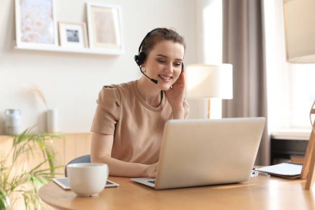 istock Freelance operator talking with headsets and consulting clients from home office. 1283311388