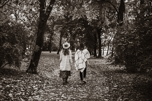 Sepia photo of two ladies walking in the park