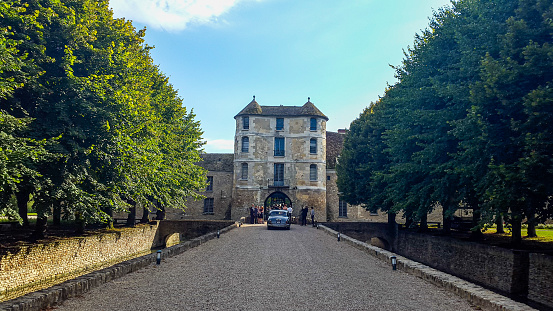 In August 2015, tourists were walking on the alley leading to the Villiers-Le-Mahieu castle to do a visit of the site, France.