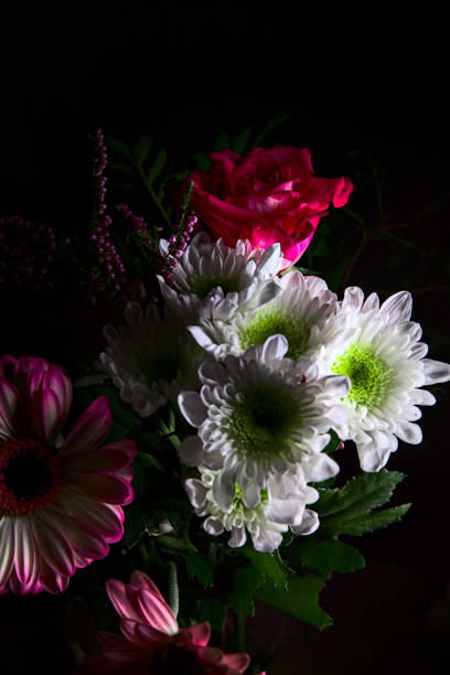 istock Bouquet of chrysanthemums and gerberas with a rose on a black background 1283319773