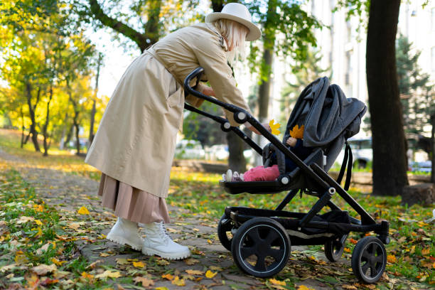 istock Mother with baby pram walking in autumn park 1283320558