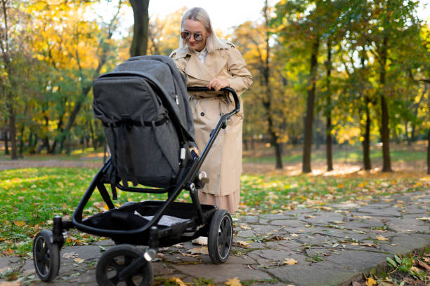 istock Mother with baby pram walking in autumn park 1283320564