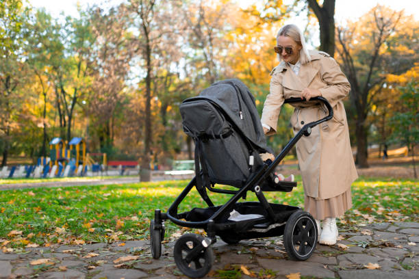 istock Mother with baby pram walking in autumn park 1283320604