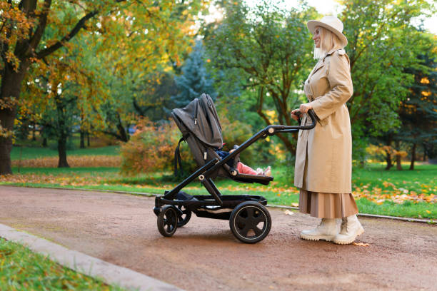istock Mom with a stroller in the autumn park 1283320643