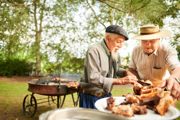 istock Senior men cutting up meat during a summer barbecue 1283322187