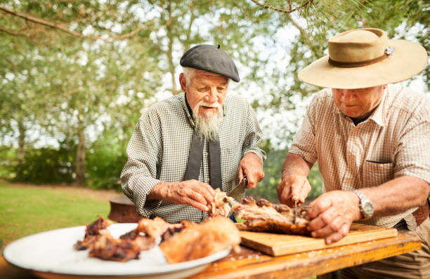 istock Senior men chopping up meat during a summer barbecue 1283322304