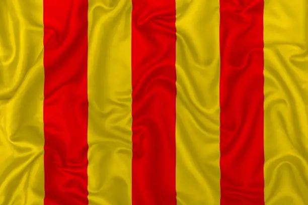 County of Foix flag on wavy silk textile fabric background.