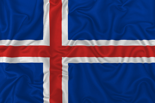 Iceland country flag on wavy silk textile fabric background.