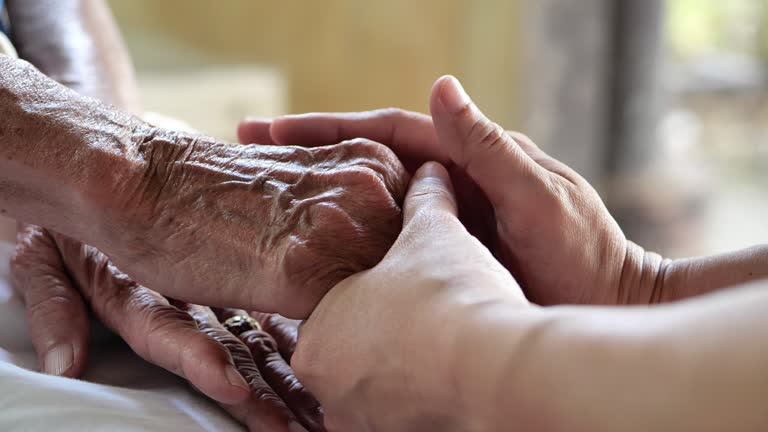 Close-up,Psychologist female sitting and touch hand depressed senior women for encouragement visit at clinic.Modern mental health concept.