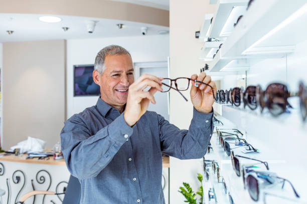 istock Man trying on glasses on mirror in optician 1283331177