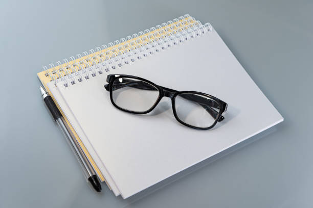 istock stack of notebooks and glasses are on the table. 1283331546