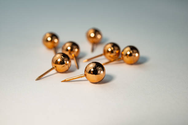group of gold-colored chalkboard pins lie on a light background. Business concept. Web banner.