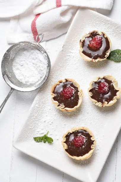 Chocolate Mousse in pastry shells with raspberries and powdered sugar.