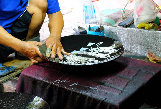 Ho Chi Minh City, Vietnam - March 28, 2019: The process of handcrafting Vietnamese souvenir of a picture of mother of pearl or eggshell in a craft center. Photo taken in low light, selective focus