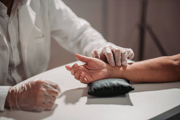 Asian chinese male acupuncturists taking pulse diagnosis works for his patient at chinese medicine shop crop shot of chinese medicine doctor measuring pulse with hand for his patient chinese herbal medicine stock pictures, royalty-free photos & images