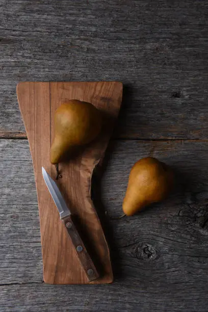Bosc Pears on a cutting board with knife.