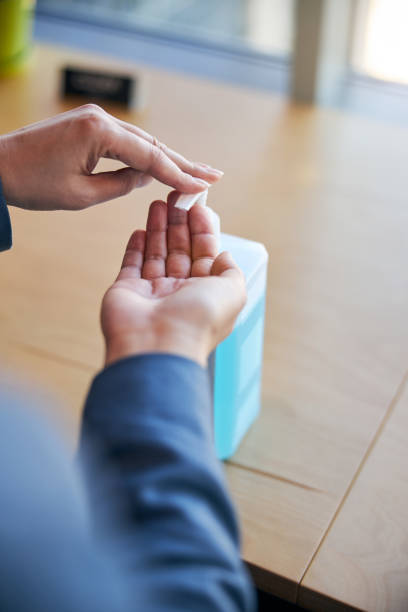 istock Woman using alcohol-based sanitizer to disinfect her hands 1283340882