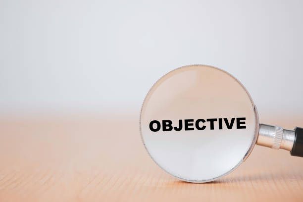 istock Business objective target and goal concept, Black Objective wording on magnifier glass on table. 1283341193