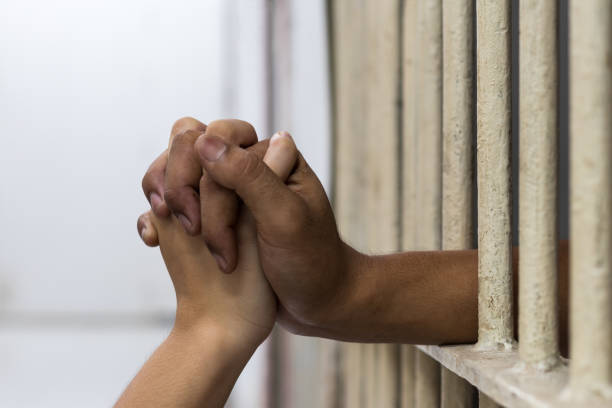istock Fingers clasped together in a white cage room. 1283341256