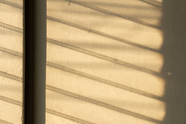 istock Sunlight shadow on the wall from the louver window. 1283341364