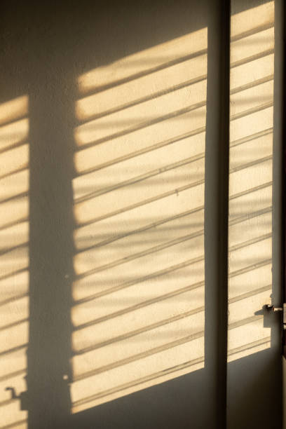 istock Sunlight shadow on the wall from the louver window. 1283341368