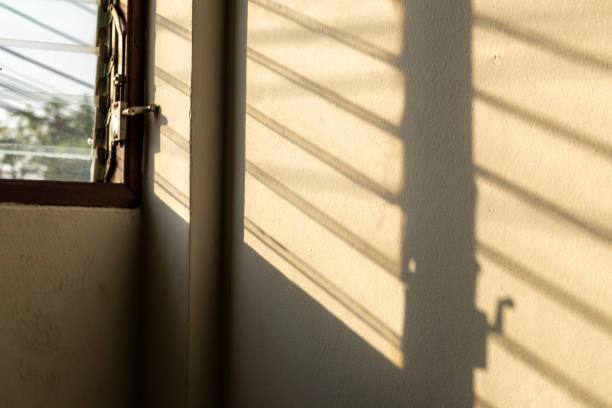 istock Sunlight shadow on the wall with old louver windows. 1283341382