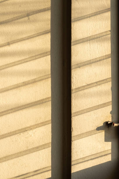 istock Sunlight shadow on the wall from the louver window. 1283341384