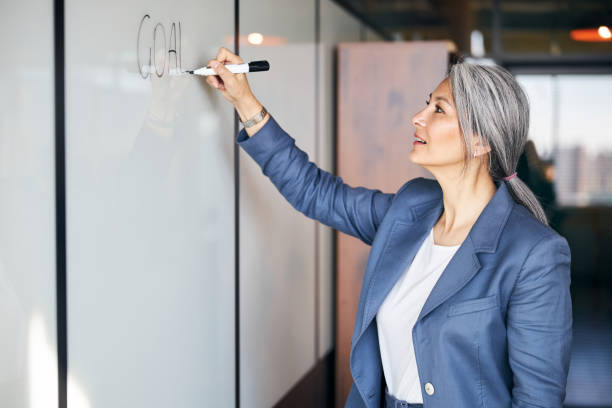 istock Beautiful woman writing on whiteboard in office 1283342249