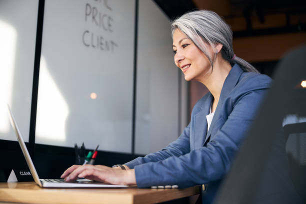 istock Cheerful woman working on modern laptop in office 1283342264